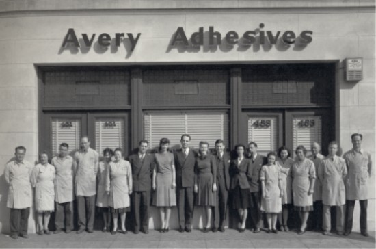 Stan Avery and his 19 employees stand in front of Avery Adhesives building.